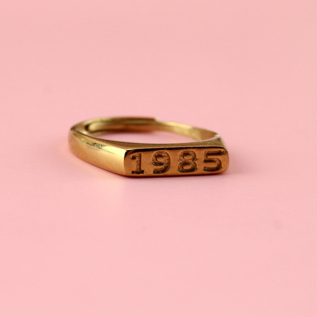 Gold plated stainless steel ring with 1985 engraved on the front