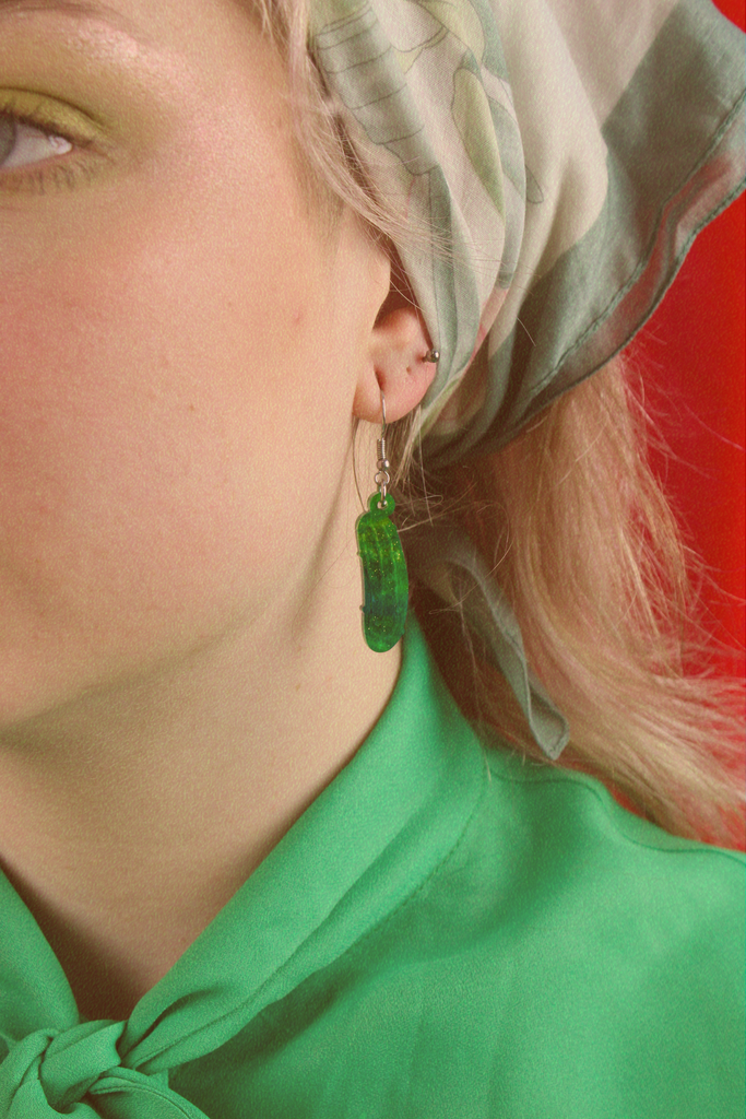 Model wearing Green acrylic dill pickle charms on stainless steel earwires