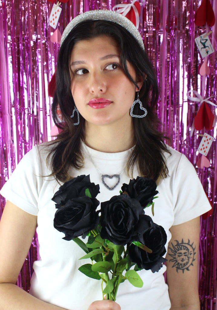 Model wearing a stainless steel chain with a cut out heart pendant with a chain style outline with matching earrings