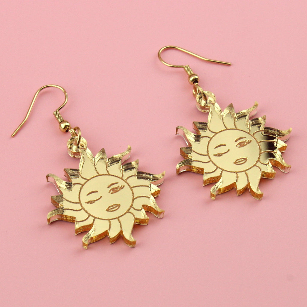 Gold mirrror acrylic charms with winking sun faces on gold plated stainless steel earwires