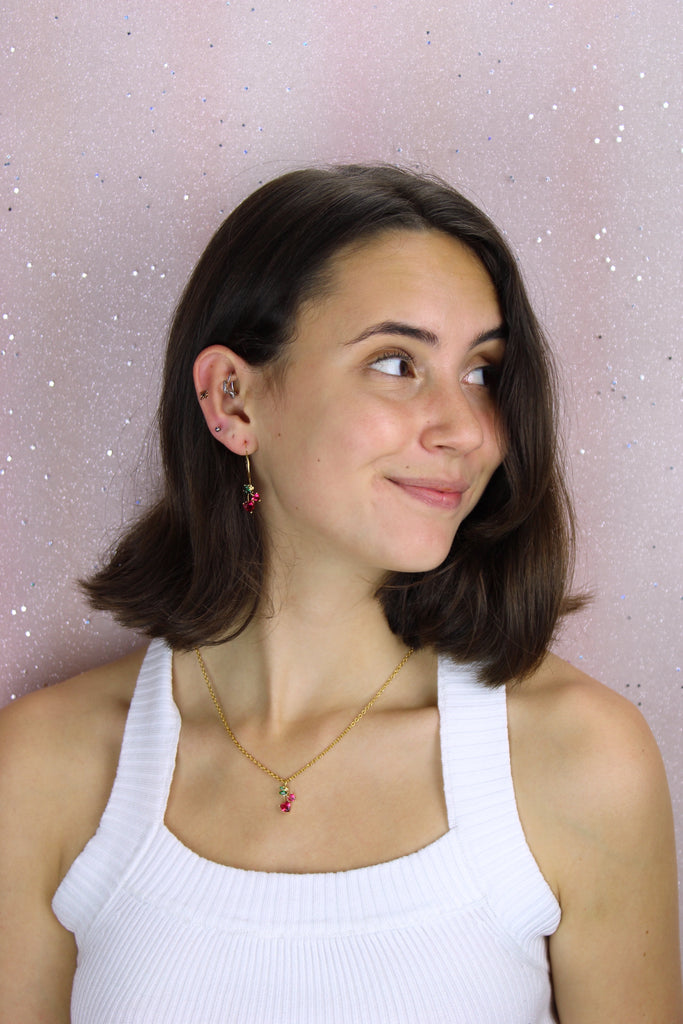 Model wearing Gold plated stainless steel hoops with glass cherry charms
