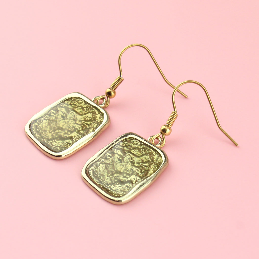 Gold rectangular shaped earrings with a wavy outline and a shimmery olive coloured centre