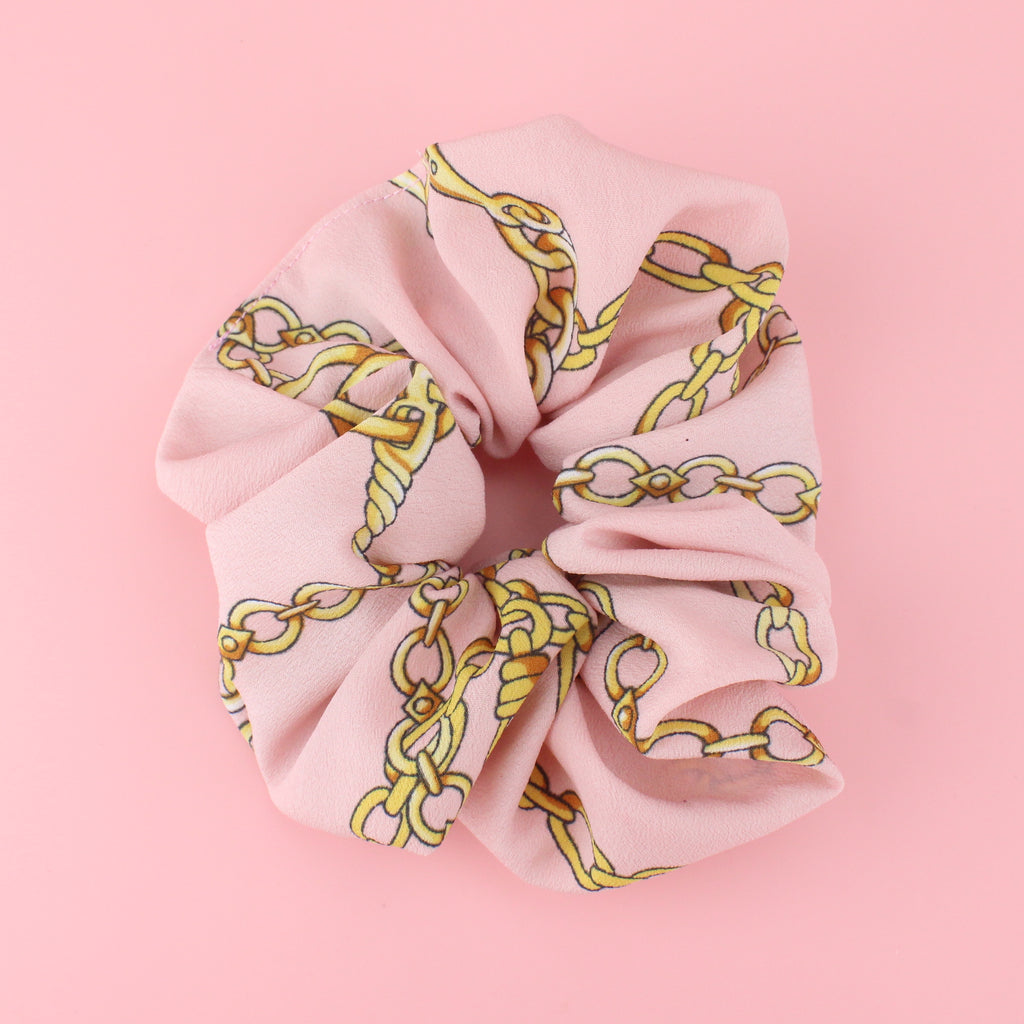 Pink scrunchie with a printed gold chain design