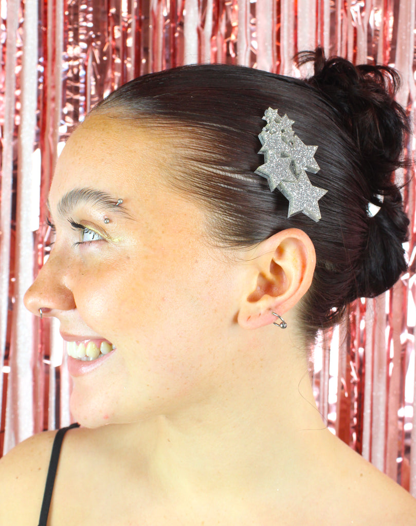 Model wearing a hair clip made up of a cluster of silver glittery stars
