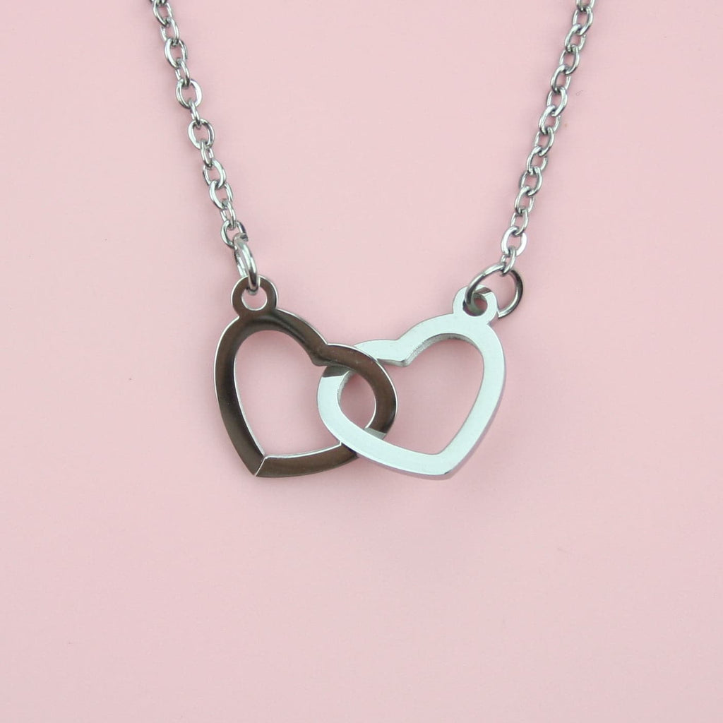Two cut out hearts linked togetther on a stainless steel chain