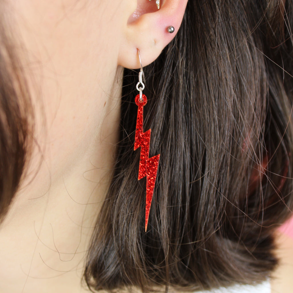 Model wearing Red Glitter Lightning Bolt Earrings 