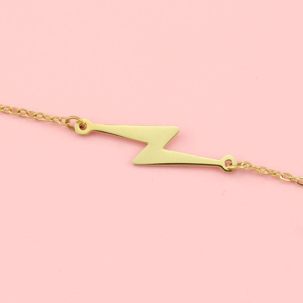 Gold plated stainless steel bracelet featuring a lightning bolt charm