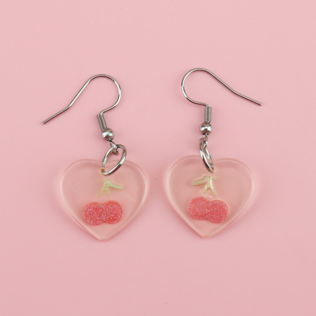 Clear resin heart charms with a glittery cherry in the middle, on stainless steel earwires