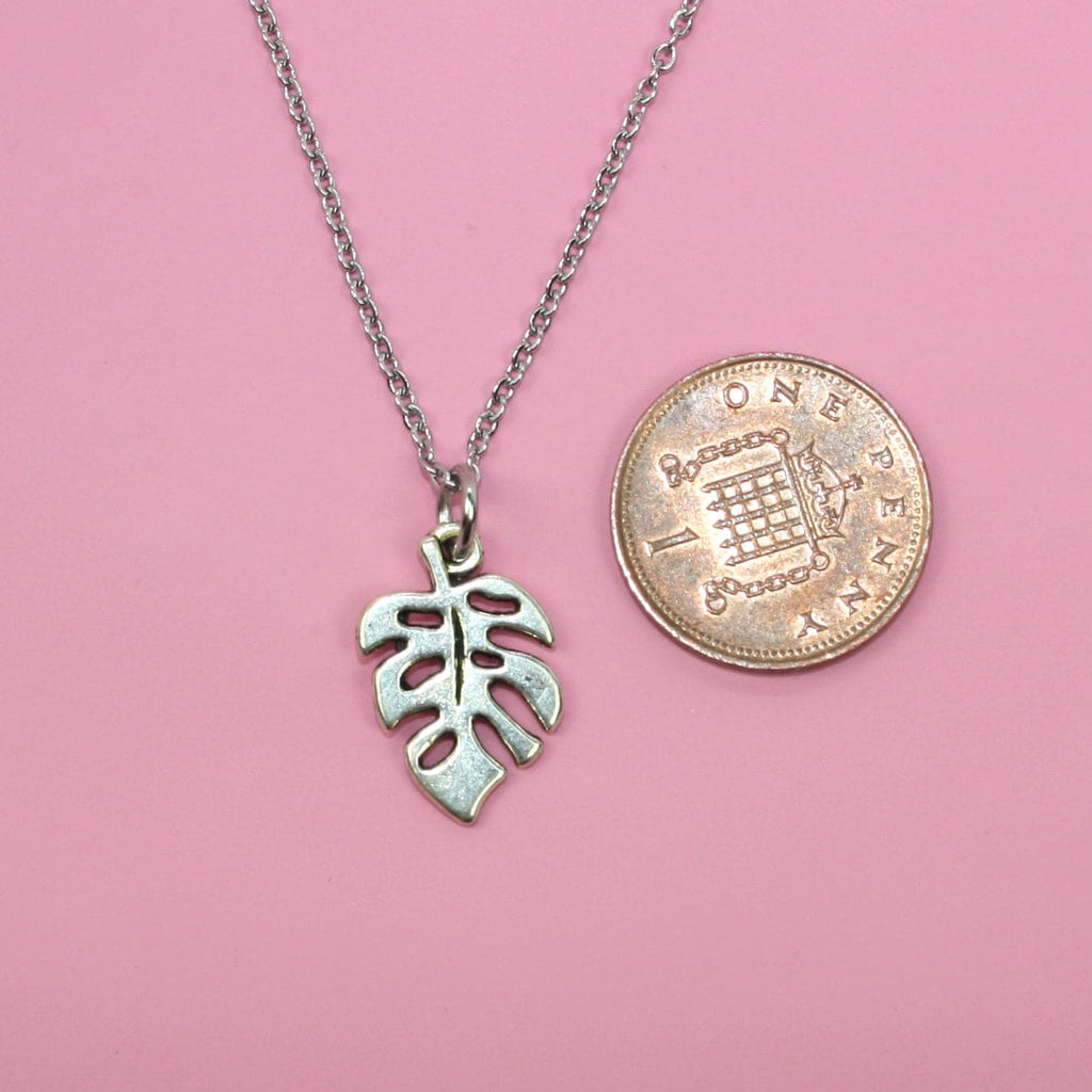 Stainless Steel Necklace with Monstera leaf charm witha penny next to it for scale