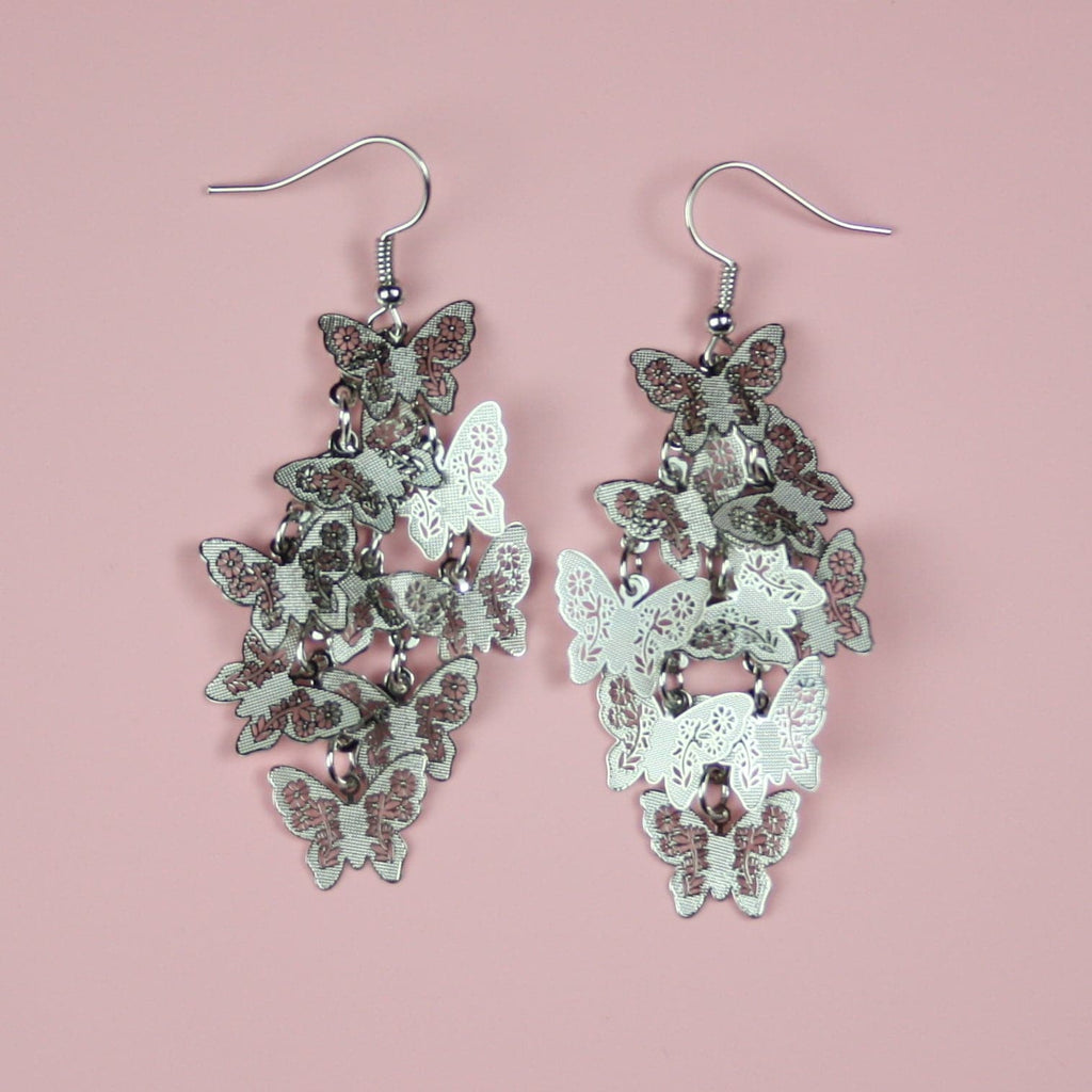 A cluster of silver butterfly earrings on stainless steel earwires
