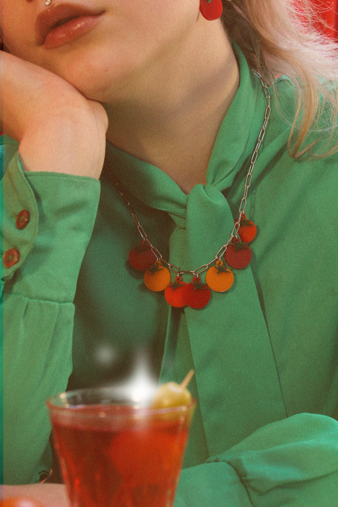 Model wearing stainless steel oval link necklace featuring seven red and orange tomato pendants with the matching earrings