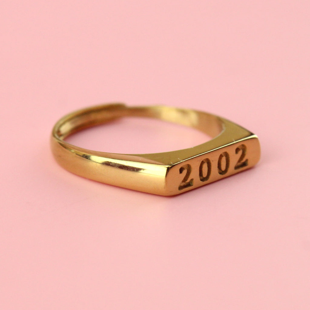 Gold plated stainless steel ring with 2002 engraved on the front