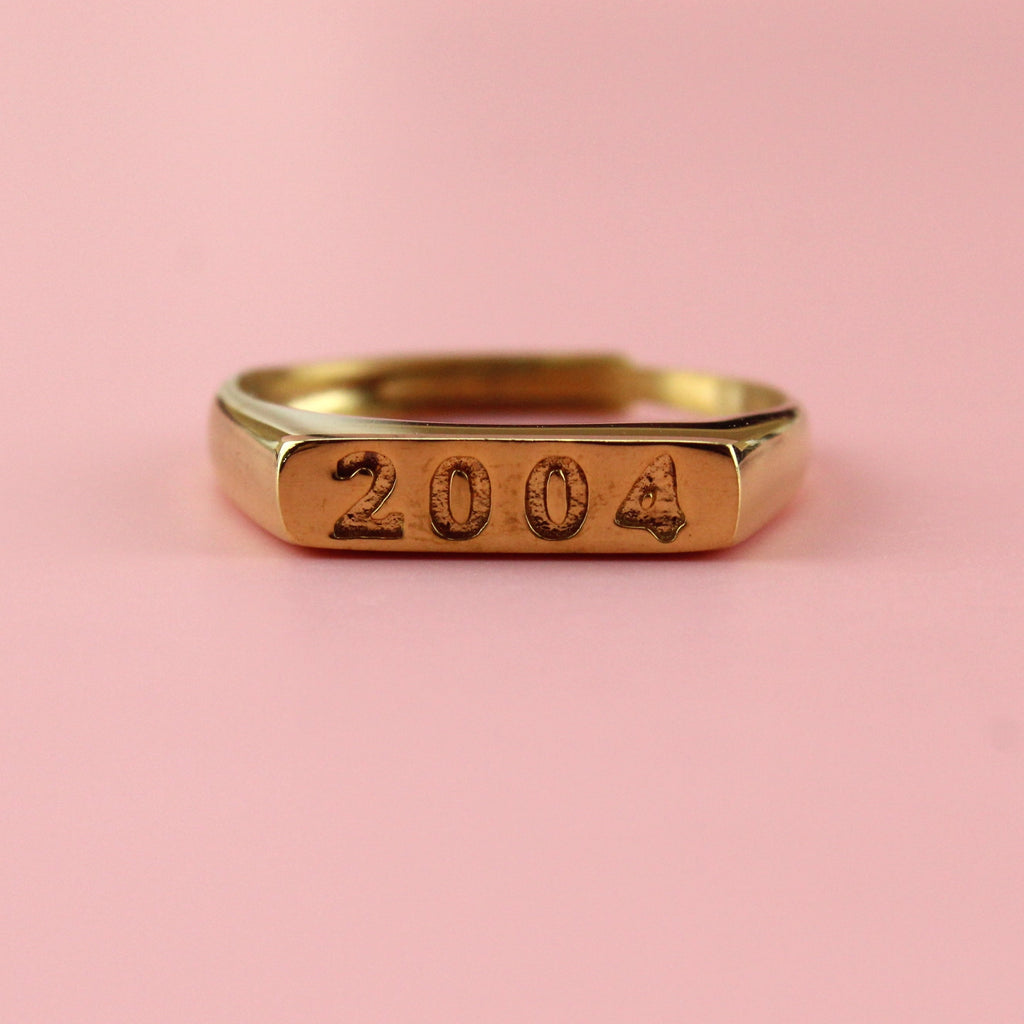 Gold plated stainless steel ring with 2004 engraved on the front