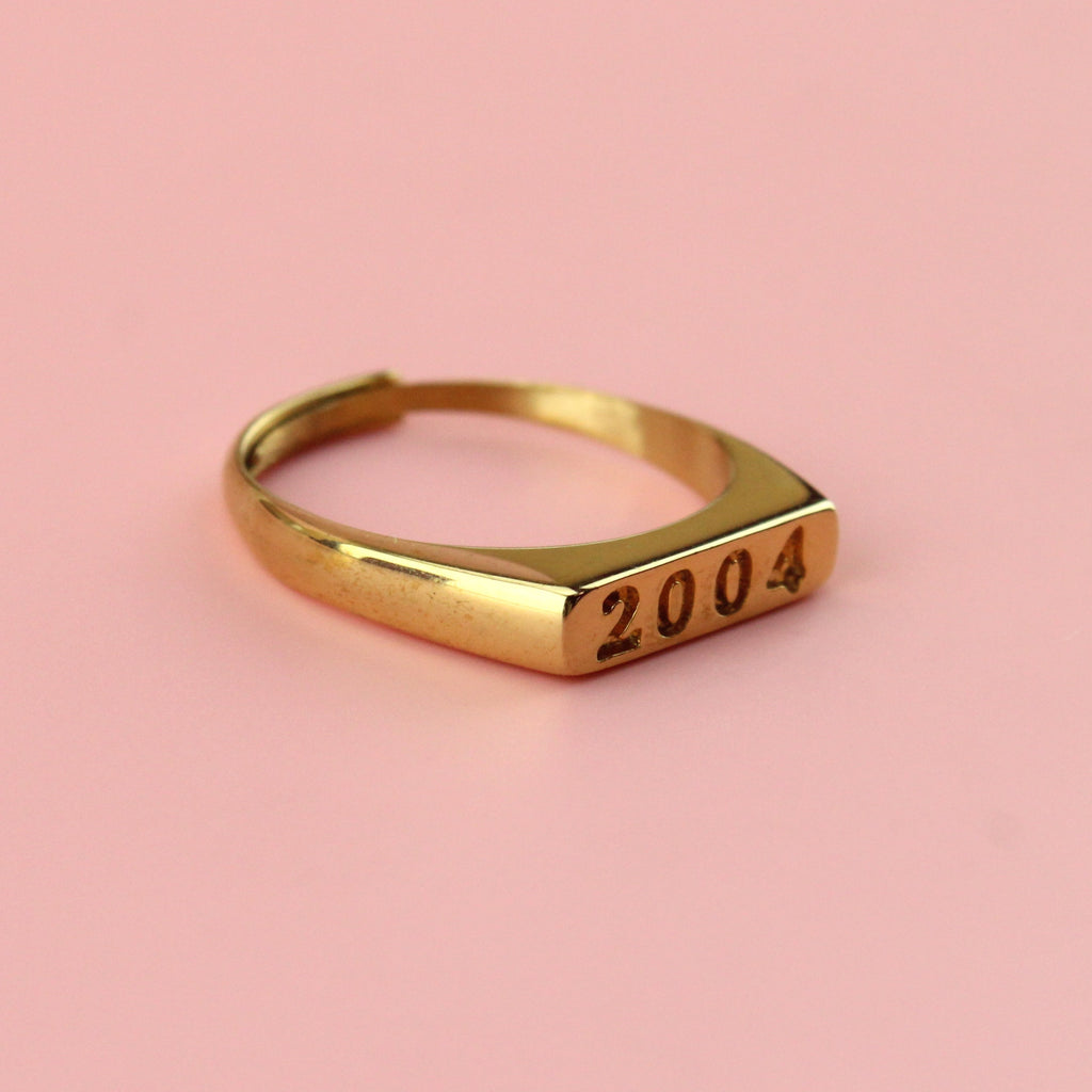 Gold plated stainless steel ring with 2004 engraved on the front