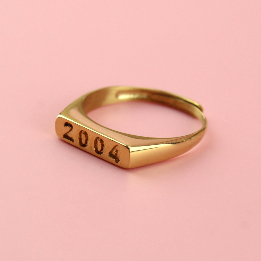 Gold plated stainless steel ring with 2004 engraved on the front