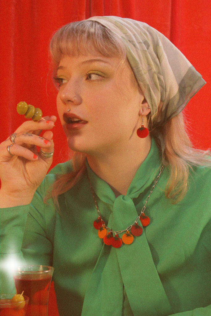 Model wearing stainless steel oval link necklace featuring seven red and orange tomato pendants with the matching earrings