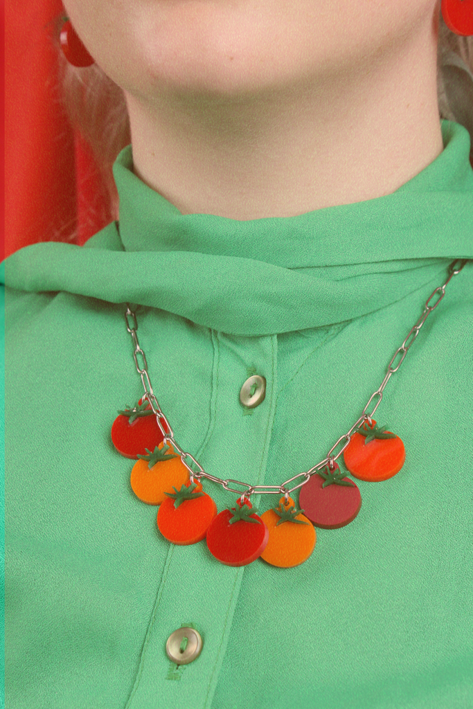 Model wearing stainless steel oval link necklace featuring seven red and orange tomato pendants with the matching earrings