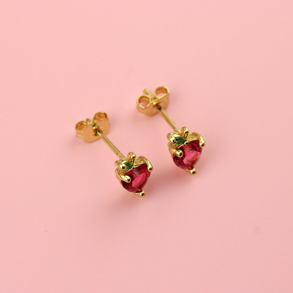 Apple shaped studs with red and green cubic zirconia and gold balls around the apple on gold plated base metal studs