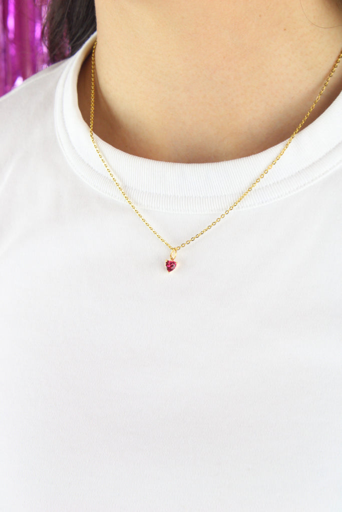 Model wearing gold plated stainless steel chain with a small red heart glass-effect pendant