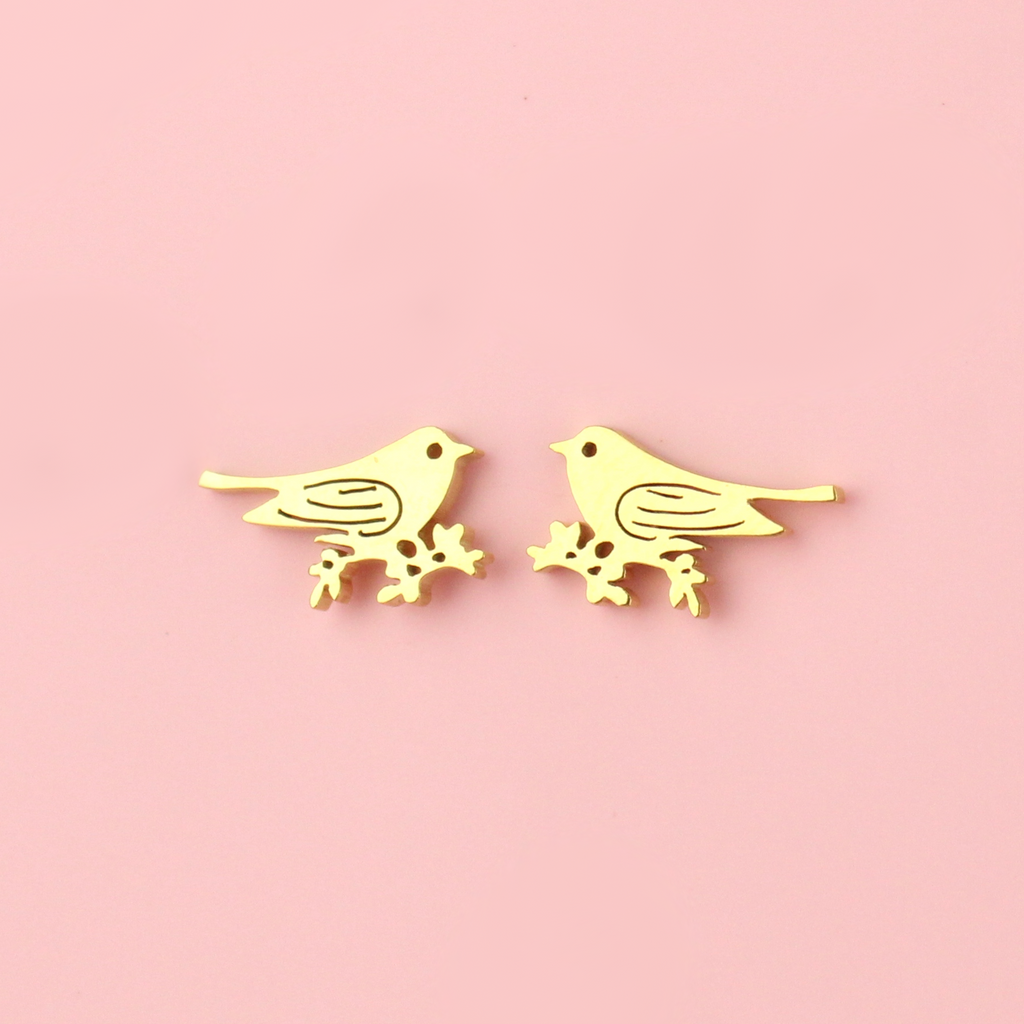 Gold plated stainless steel studs in the shape of a bird perched on a branch