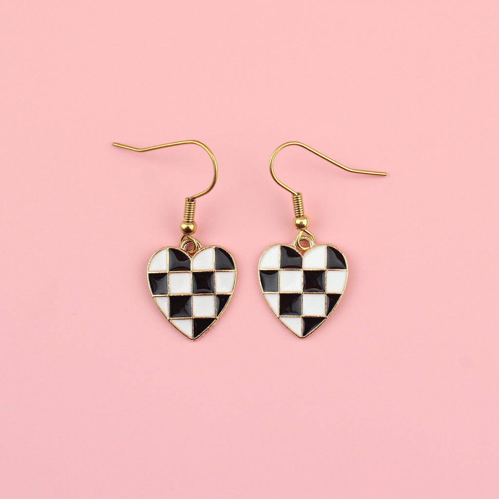 Black and white base metal charms with black and white enamel checkerboard design in the shape of a heart on gold plated stainless steel earwires