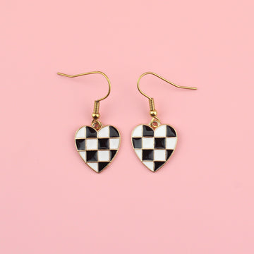 Black and white base metal charms with black and white enamel checkerboard design in the shape of a heart on gold plated stainless steel earwires