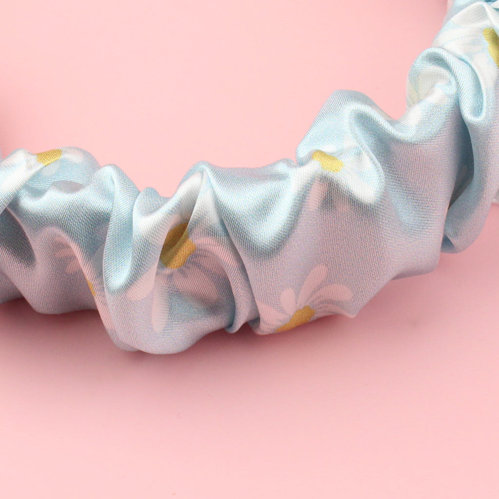 Pastel blue scrunchie style headband with a daisy design