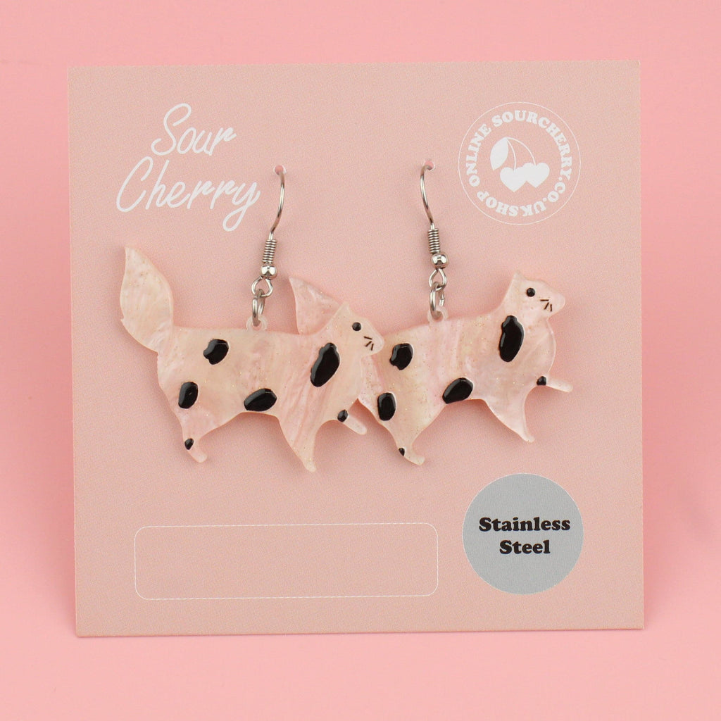 3D cat resin charms with pink glitter and black splodges on stainless steel earwires shown on the card