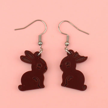 charms in the shape of chocolate bunnies with a bite taken out of one ear on stainless steel earwires