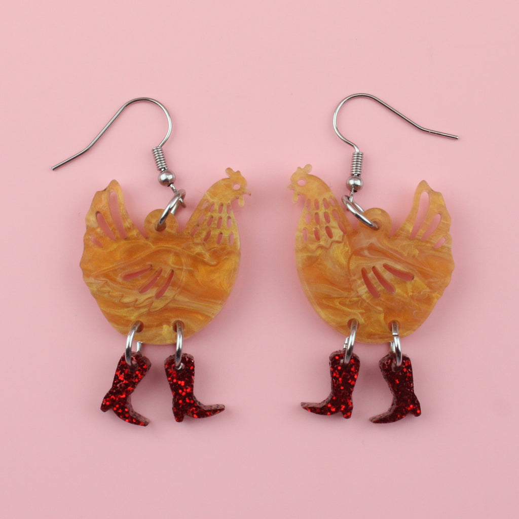Brown marble acrylic chicken charms with red glittery cowboy boots on stainless steel earwires