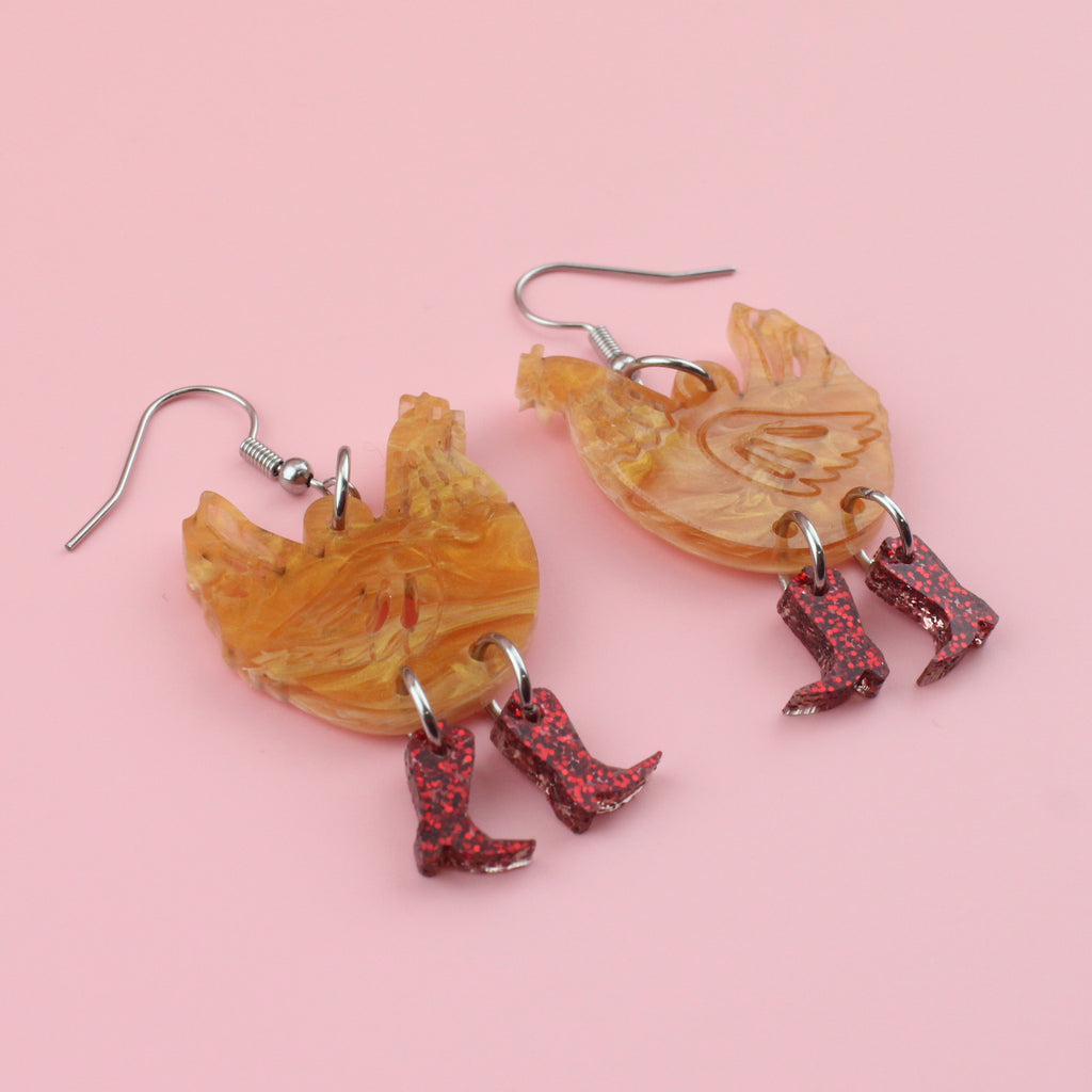 Brown marble acrylic chicken charms with red glittery cowboy boots on stainless steel earwire