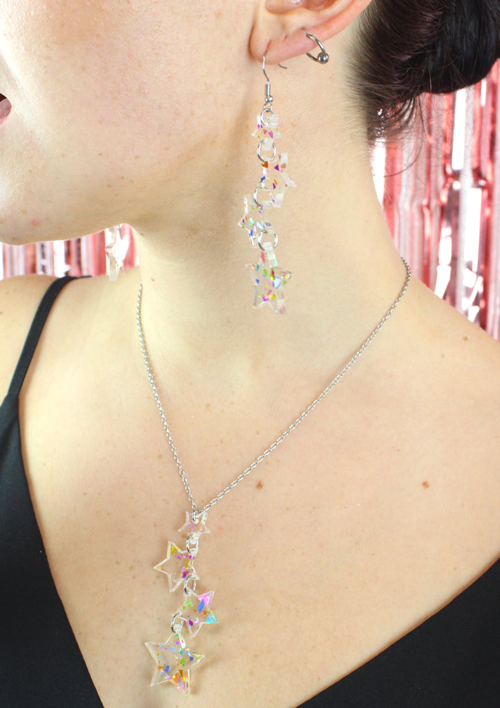 Model wearing confetti star charms on a stainless steel chain with matching earrings