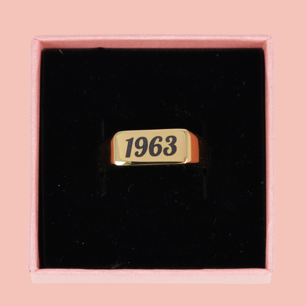 gold plated titanium with birth year engraved in black shown in a gift box