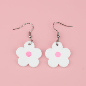 White perspex daisy charms with a pink glow in the dark resin centre on stainless steel earwires