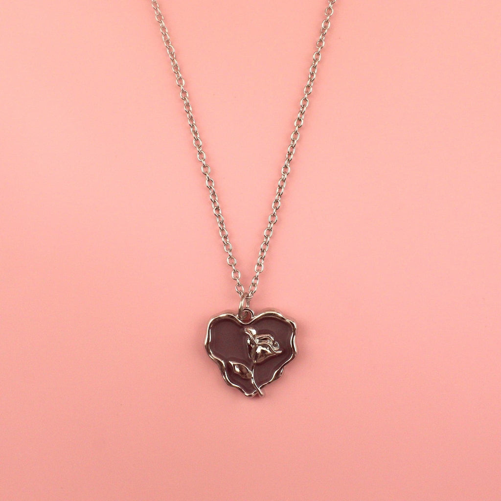 Dark brown heart pendant with silver outline and silver rose in the middle on a stainless steel chain