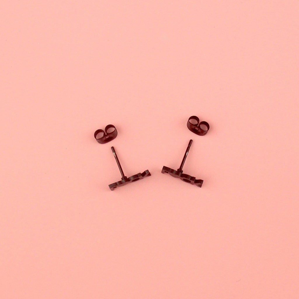 Black stud earrings with the word F*CK, the U being replaced with a heart