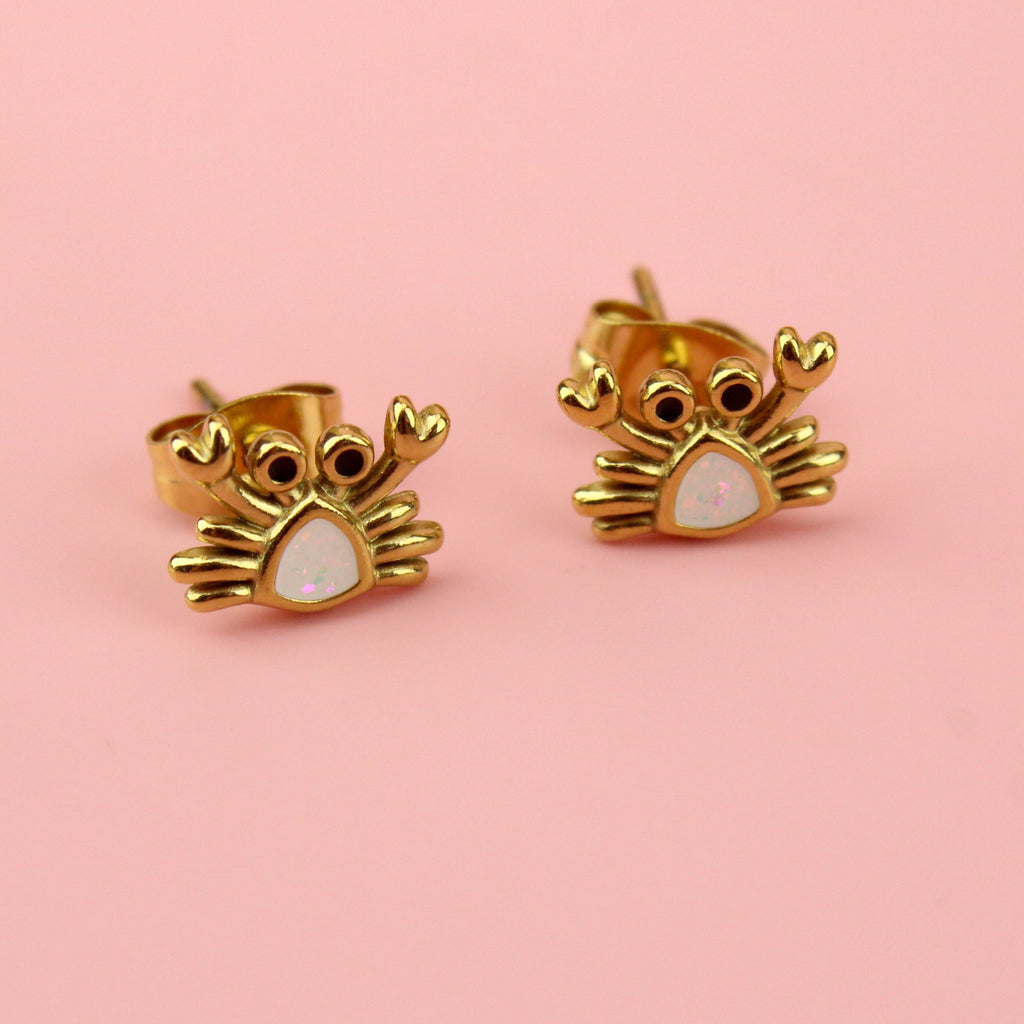 Crab shaped gold plated stainless steel studs with a white middle