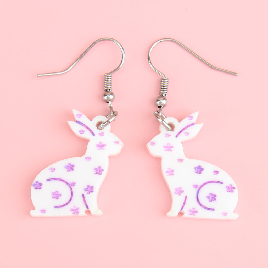white acrylic bunnies with hand-painted purple flowers on stainless steel earwires 