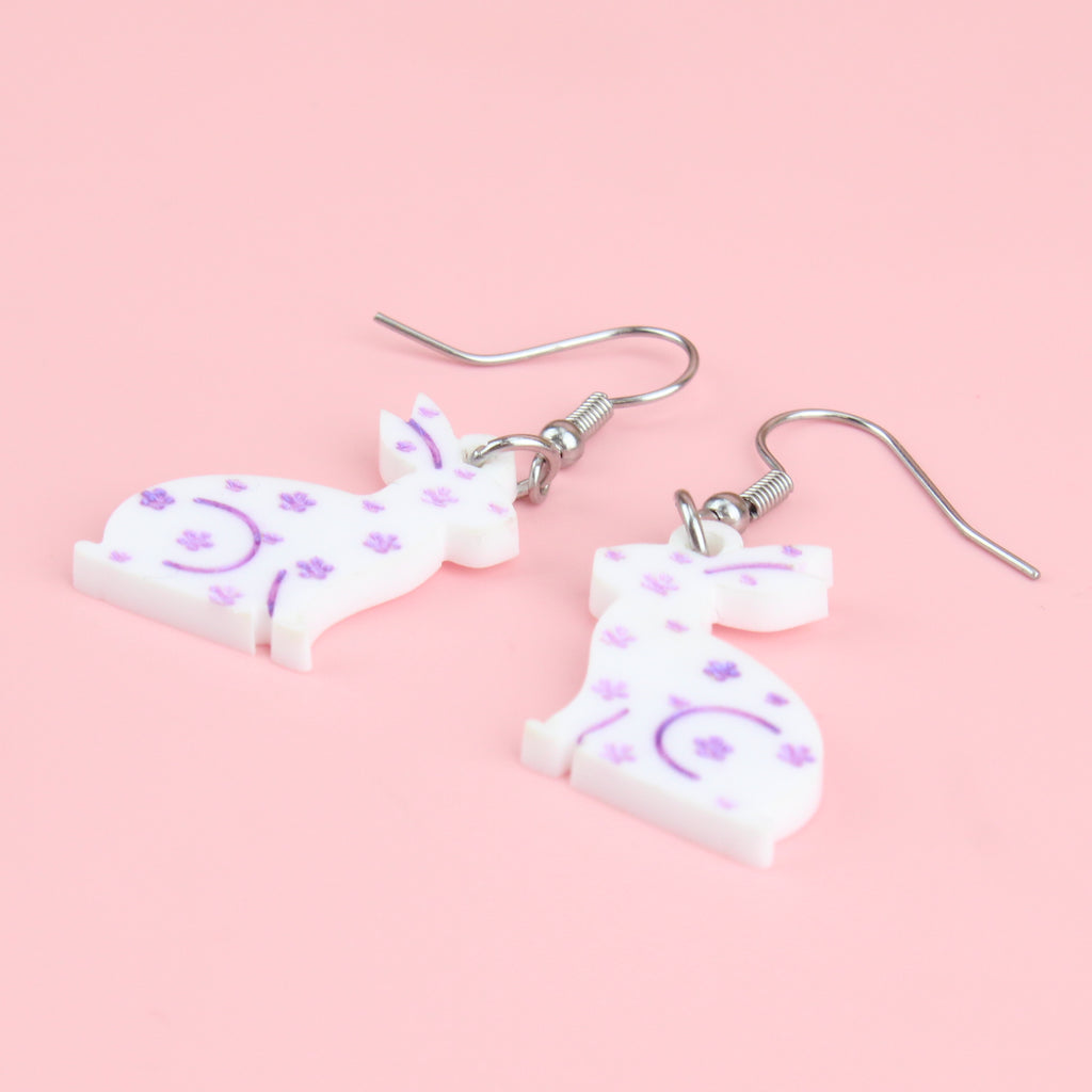 white acrylic bunnies with hand-painted purple flowers on stainless steel earwires