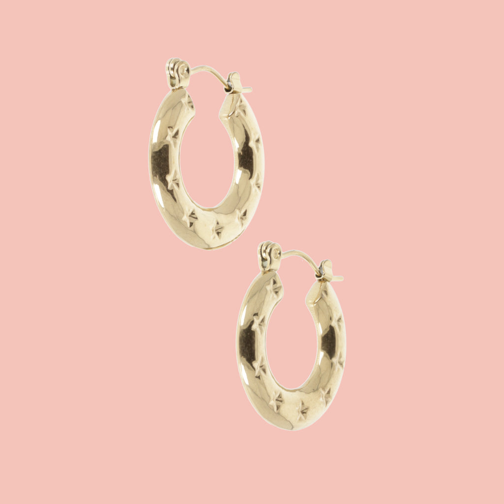 Gold horseshoe-shaped earring with stars surrounding the horsehoe