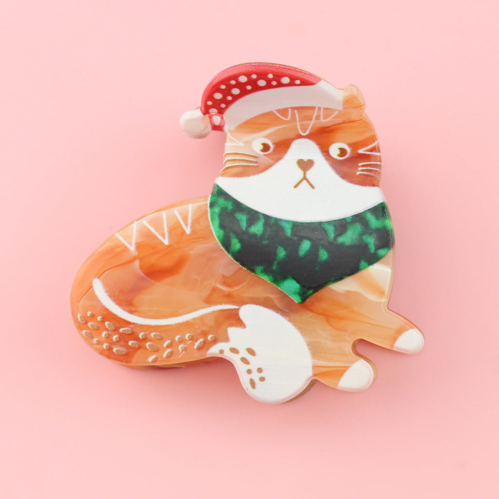claw clip featuring a Ginger cat  with a santa hat and a green bandana