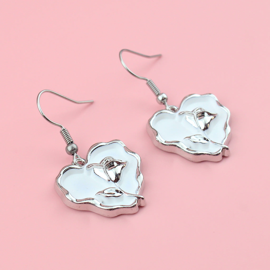 White heart charms with a silver outline and a silver rose in the middle on stainless steel earwires