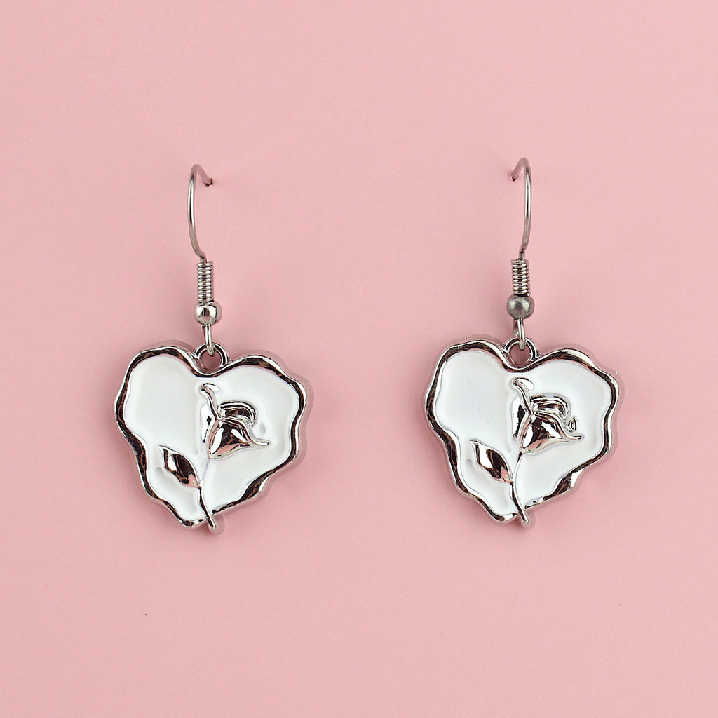 White heart charms with a silver outline and a silver rose in the middle on stainless steel earwires