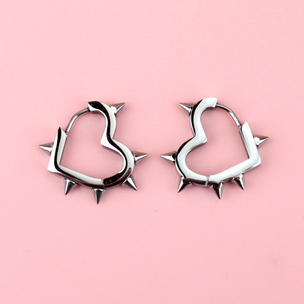 Stainless steel heart shaped hoops with punk-inspired spikes surrounding the edge
