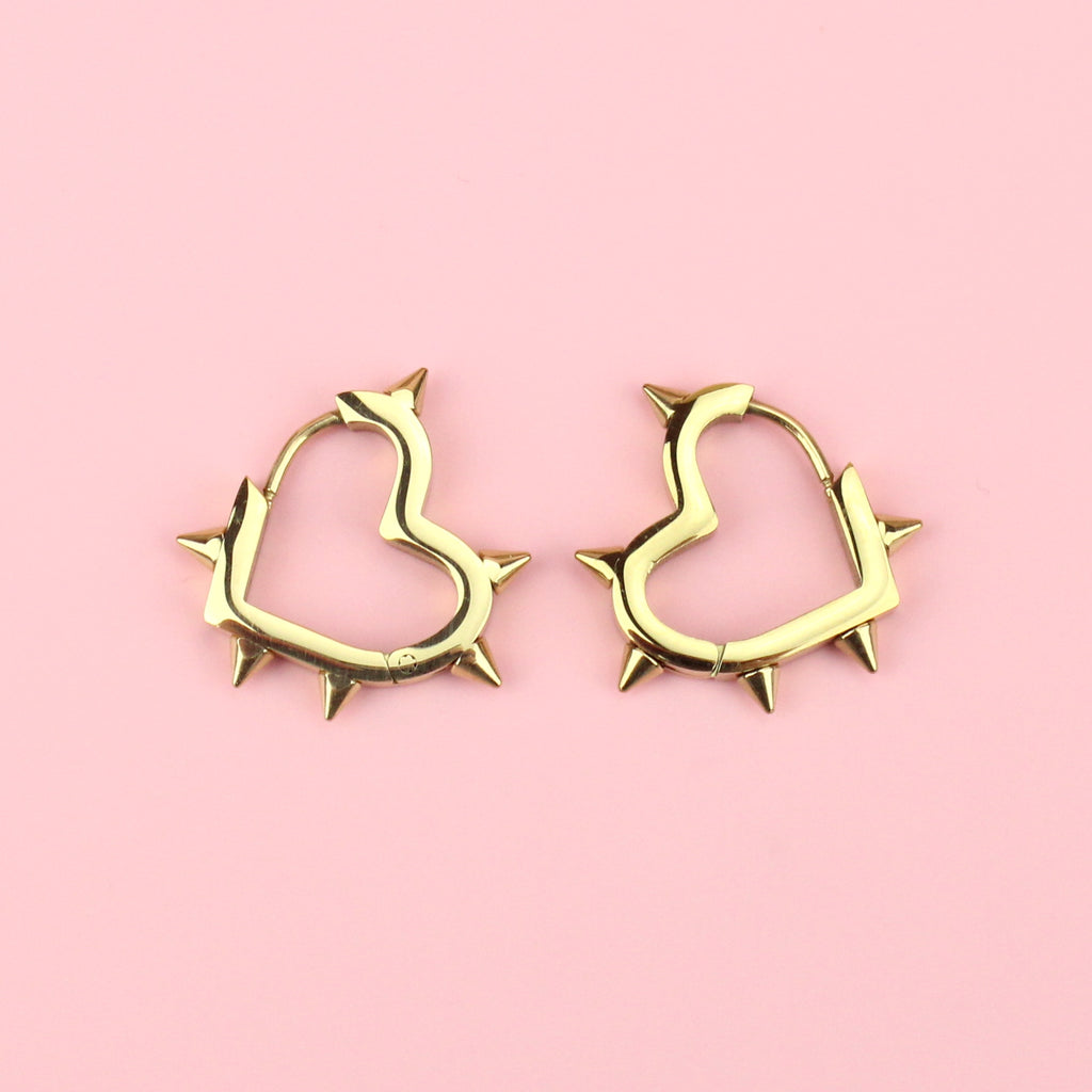 Gold plated stainless steel heart shaped hoops with punk-inspired spikes surrounding the edge