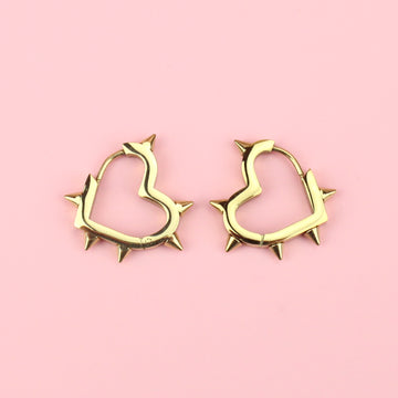 Gold plated stainless steel heart shaped hoops with punk-inspired spikes surrounding the edge