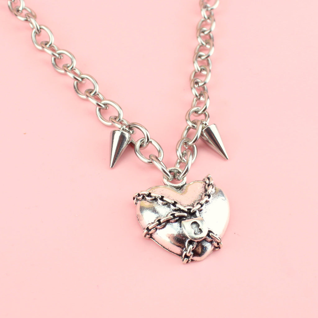 Heart pendant wrapped in chains featuring two spikes either side of the titaniumchain