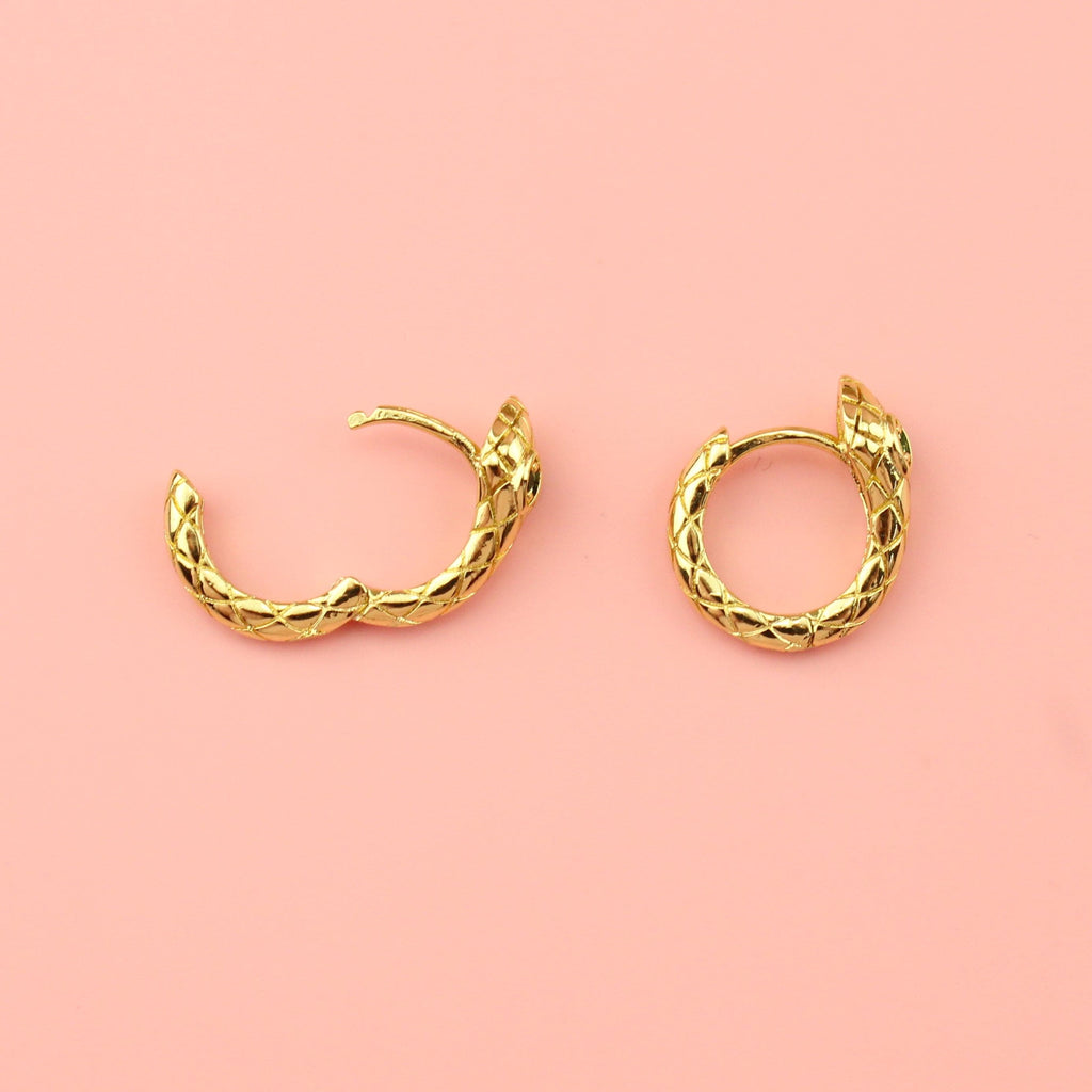 Gold plated snake hoop earrings featuring green cubic zirconia eyes