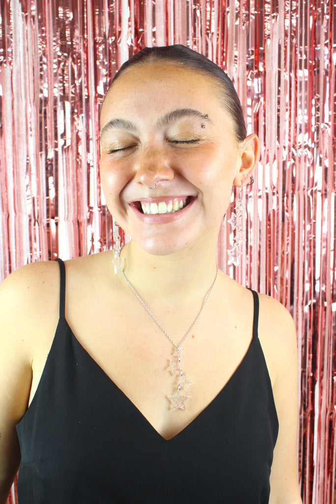 Model wearing holographic glitter star charms on a stainless steel chain