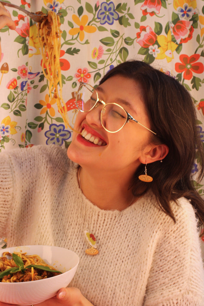 Model wearing acrylic charms that feature a delicious plate of spag bol and garlic bread on stainless steel earwires. Model is also wearing the matching necklace.